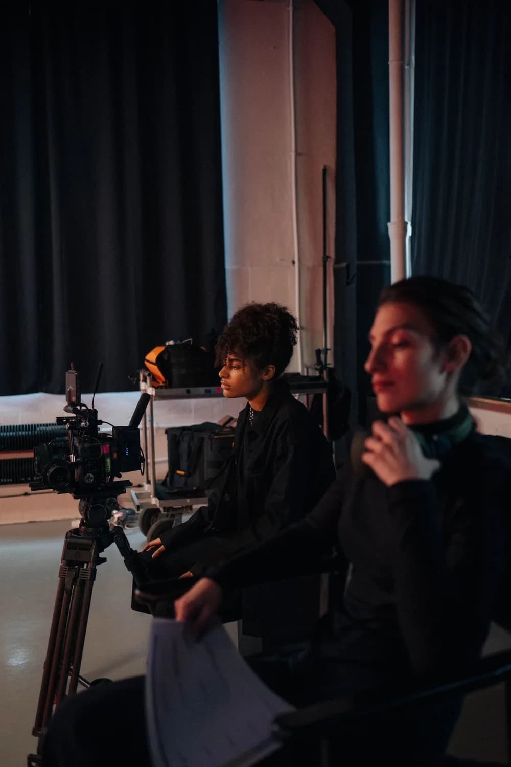 Camera operator and production colleague working together on a studio set